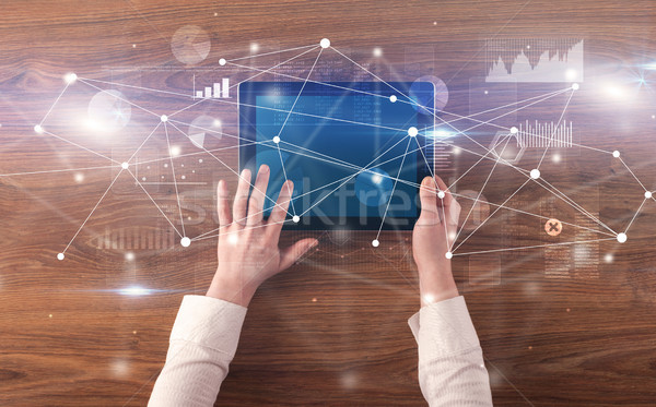 Hand holding tablet with linked graphs and charts concept Stock photo © ra2studio