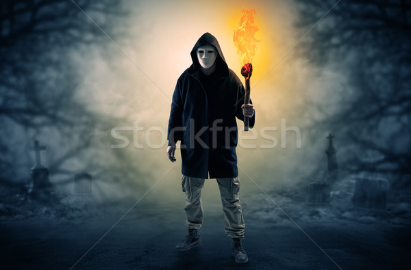 Man coming out from a thicket with burning flambeau Stock photo © ra2studio