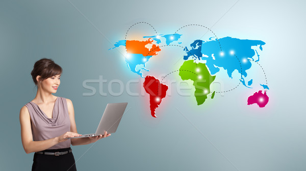 Young woman holding a laptop and presenting colorful world map Stock photo © ra2studio