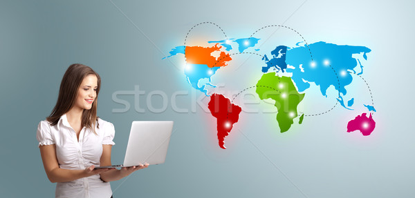 Young woman holding a laptop and presenting colorful world map Stock photo © ra2studio