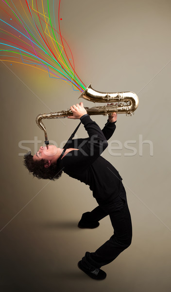 Attractive musician playing on saxophone while colorful abstract Stock photo © ra2studio