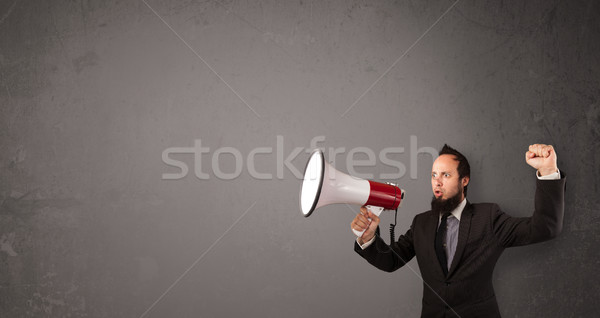 Guy shouting into megaphone on copy space background Stock photo © ra2studio