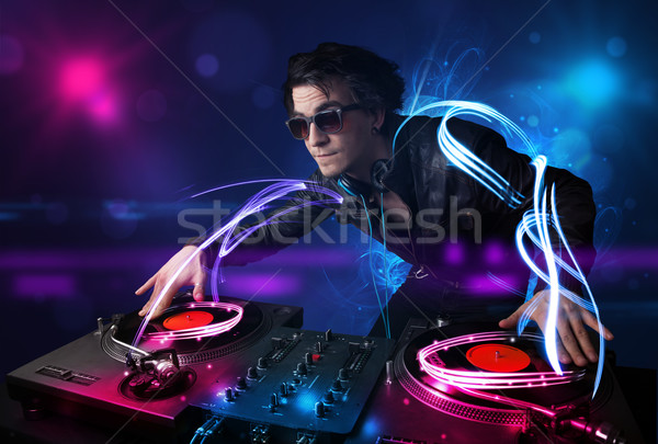 Disc jockey playing music with electro light effects and lights Stock photo © ra2studio