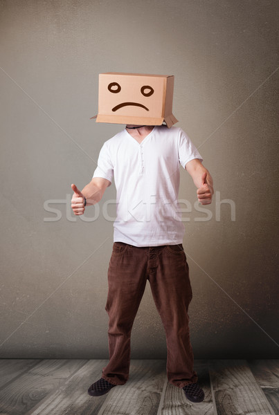 Young man with a brown cardboard box on his head with sad face Stock photo © ra2studio