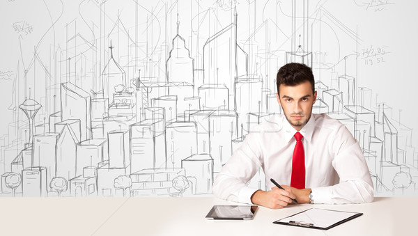 Businessman sitting at the white table with hand drawn buildings Stock photo © ra2studio