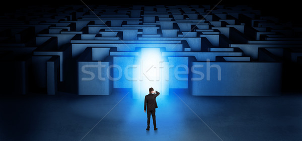 Stock photo: Lost businessman standing at illuminated labyrinth entrance