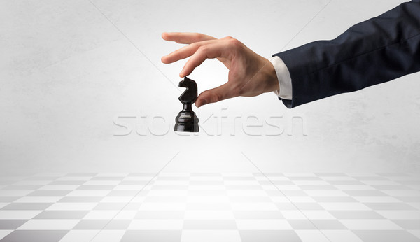 Stock photo: Big hand taking his next step on chess game
