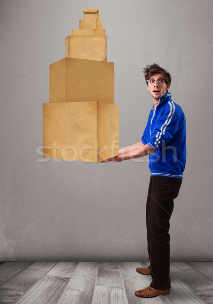 Young man holding a set of brown cardboard boxes Stock photo © ra2studio