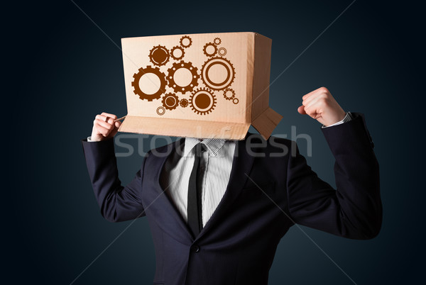 Businessman gesturing with a cardboard box on his head with spur Stock photo © ra2studio