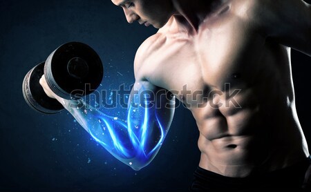 Muscular body builder lifting weight with energy lights on bicep Stock photo © ra2studio