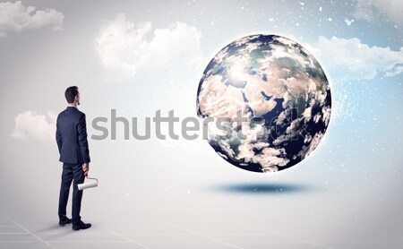 Businessman on rock mountain with a globe Stock photo © ra2studio