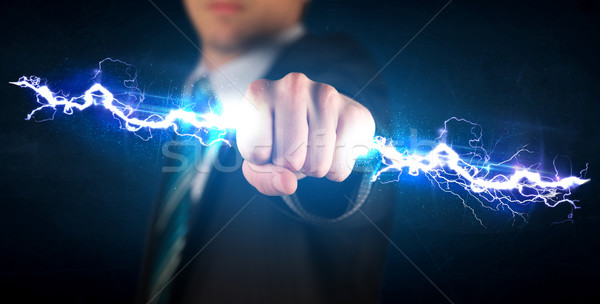 Business man holding electricity light bolt in his hands Stock photo © ra2studio