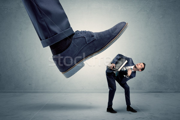 Employee getting trampled by big shoe Stock photo © ra2studio