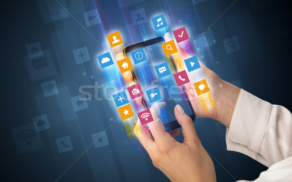 Hand using smartphone with angular app icons Stock photo © ra2studio