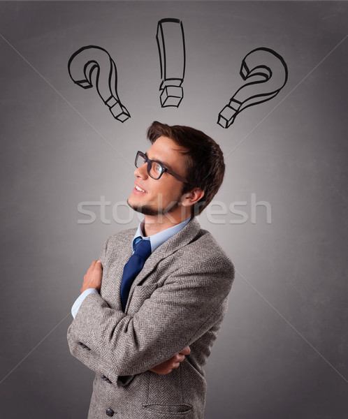 Stock photo: Young man thinking with question marks overhead