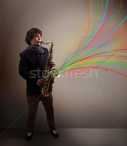 Attractive musician playing on saxophone while colorful abstract Stock photo © ra2studio