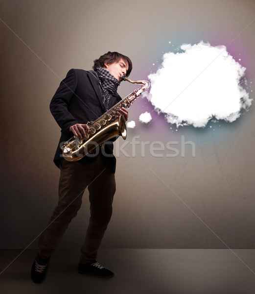 Young man playing on saxophone with copy space in white cloud Stock photo © ra2studio