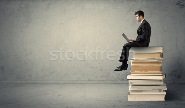 Uomo laptop seduta libri grave imprenditore Foto d'archivio © ra2studio