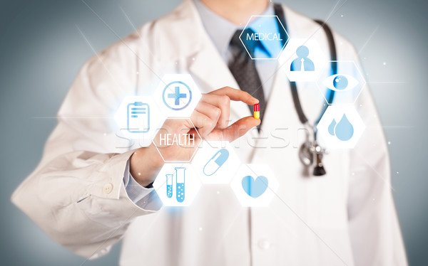 A doctor in white holding a pill Stock photo © ra2studio