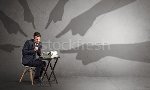 Shadow hands pointing at a small worker Stock photo © ra2studio
