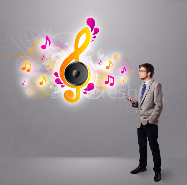 young man singing and listening to music with musical notes  Stock photo © ra2studio