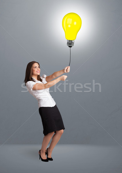 Ziemlich Dame halten Glühlampe Ballon Stock foto © ra2studio