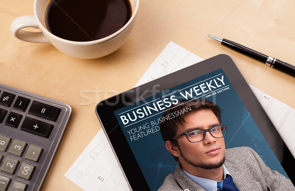 Workplace with tablet pc showing magazine cover and a cup of coffee on a wooden work table closeup Stock photo © ra2studio