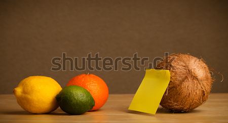 Coconut with post-it note looking at citrus fruits Stock photo © ra2studio