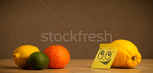 Lemon with post-it note looking at citrus fruits Stock photo © ra2studio