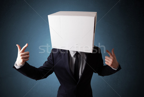 Businessman gesturing with a cardboard box on his head Stock photo © ra2studio