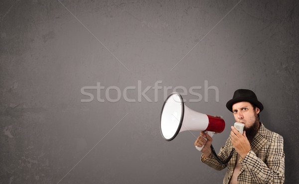 Guy shouting into megaphone on copy space background Stock photo © ra2studio