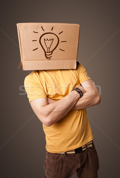 Young man gesturing with a cardboard box on his head with light  Stock photo © ra2studio