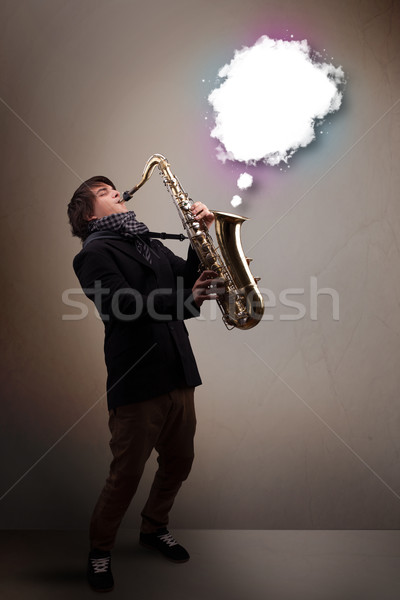 Young man playing on saxophone with copy space in white cloud Stock photo © ra2studio