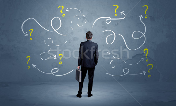 Unsure businessman with question marks Stock photo © ra2studio