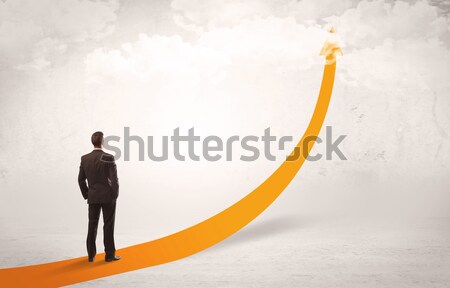 Business person standing on orange arrow Stock photo © ra2studio