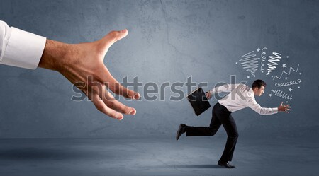 Stock photo: Stressful businessman running from a big hand 