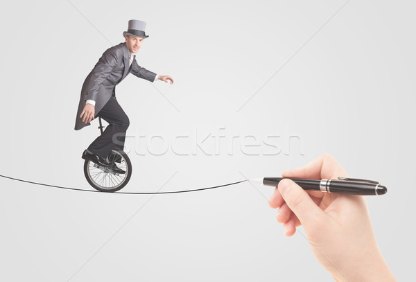 Businessman riding monocycle on a rope drawn by hand Stock photo © ra2studio