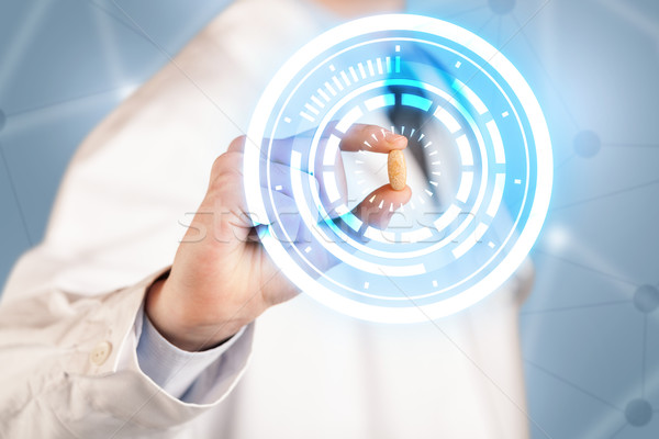 Male doctor holding a pill with glowing circles Stock photo © ra2studio