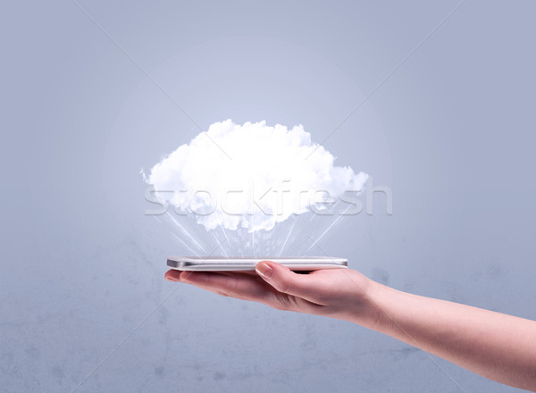 Hand holding phone with empty cloud Stock photo © ra2studio