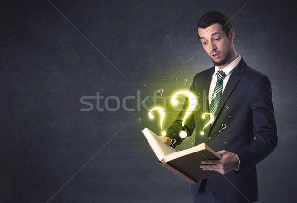 Businessman looking in a book. Stock photo © ra2studio
