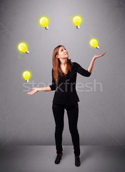 young lady standing and juggling with light bulbs Stock photo © ra2studio