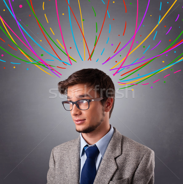 Young man thinking wiht colorful abstract lines overhead Stock photo © ra2studio