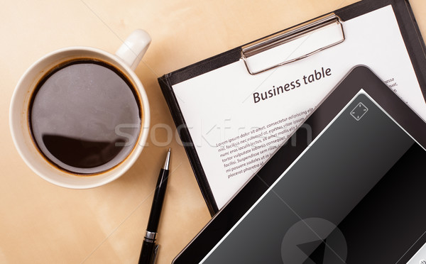 Workplace with tablet pc showing media player and a cup of coffee on a wooden work table closeup Stock photo © ra2studio