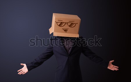 Young man gesturing with a cardboard box on his head with spur w Stock photo © ra2studio