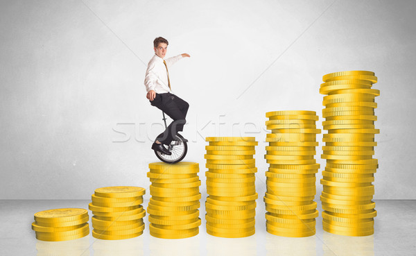 Business man riding monocycle up on coin graph Stock photo © ra2studio