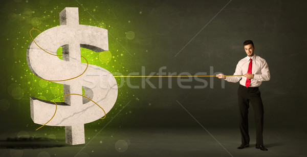 Stock photo: Business man pulling a big green dollar sign