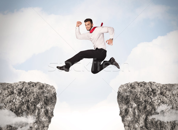 Imagine de stoc: Amuzant · om · de · afaceri · jumping · roci · decalaj · afaceri