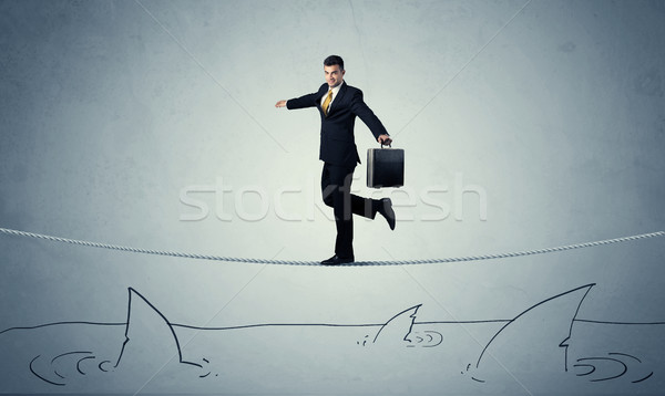 Businessman walking on rope above sharks Stock photo © ra2studio