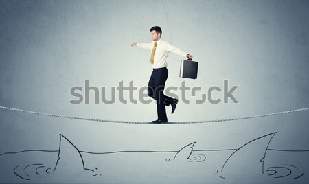 Businessman walking on rope above sharks Stock photo © ra2studio