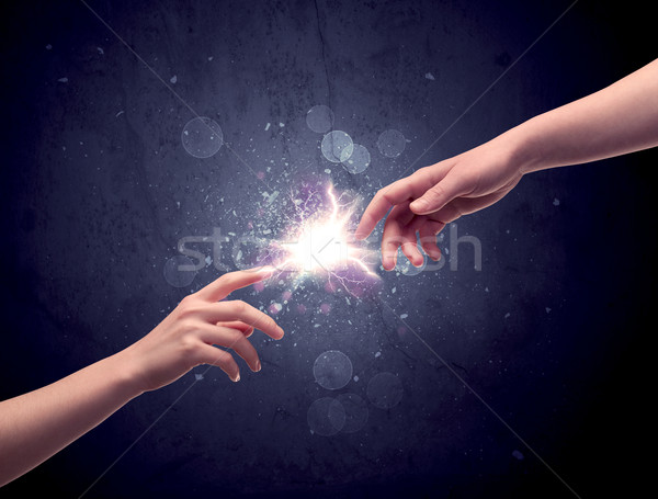 Hands reaching to light a spark Stock photo © ra2studio